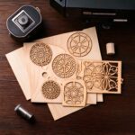 Firefly diverse holzplatten auf einem Tisch und daneben ein Lasercutter, weiter im Vordergrund dann